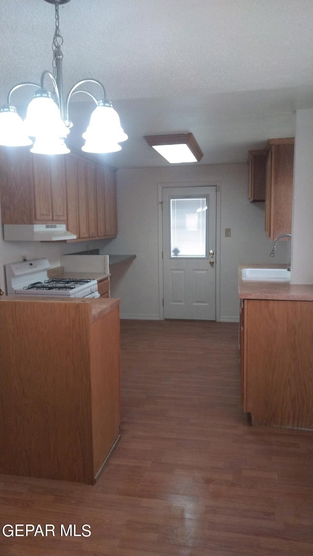 kitchen with decorative light fixtures, light wood-style flooring, a sink, white range with gas stovetop, and under cabinet range hood