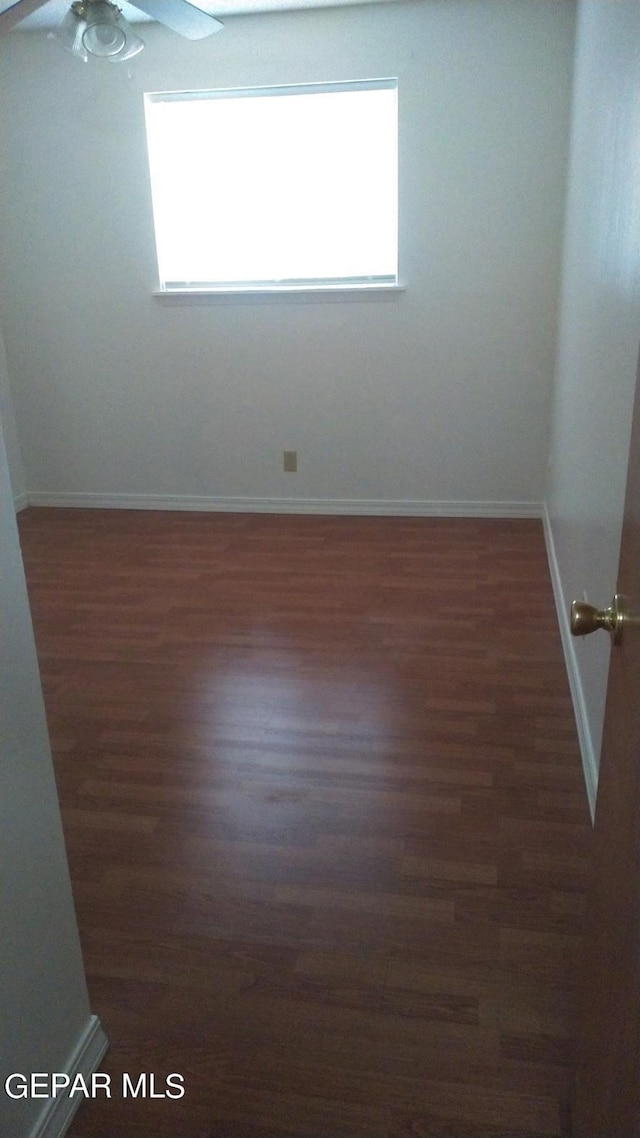 unfurnished room featuring baseboards and wood finished floors