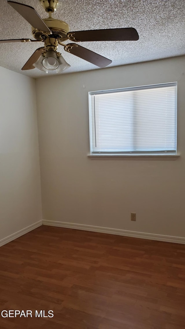 unfurnished room with a ceiling fan, baseboards, a textured ceiling, and wood finished floors