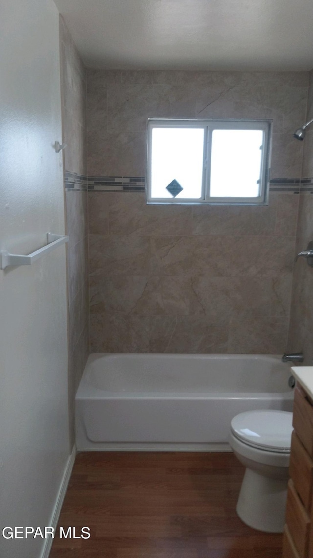 bathroom with shower / bathing tub combination, toilet, and wood finished floors