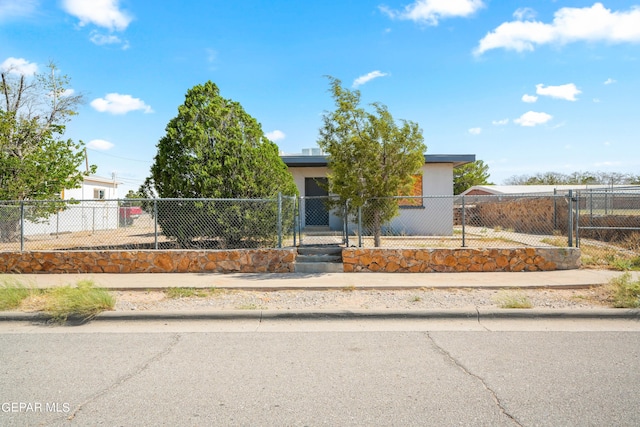 obstructed view of property featuring a fenced front yard and stucco siding