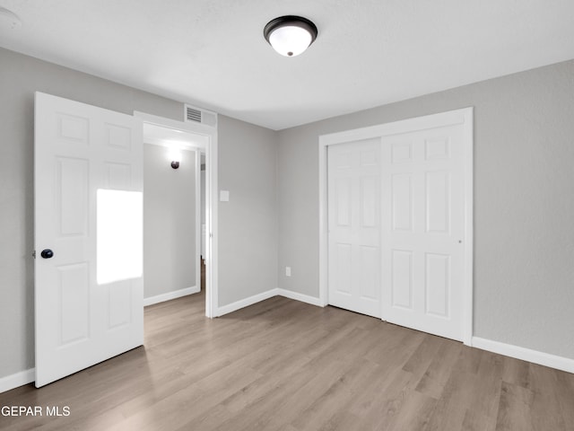 unfurnished bedroom featuring a closet and light hardwood / wood-style floors