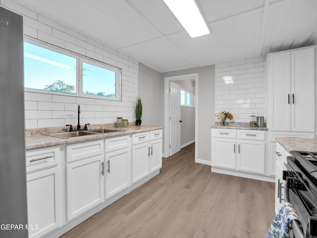 kitchen featuring decorative backsplash, white cabinetry, and plenty of natural light