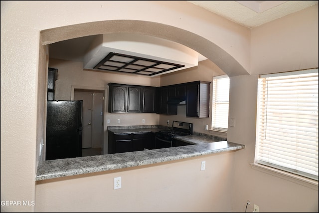 kitchen with black refrigerator and gas range oven