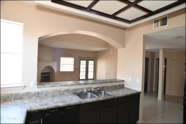 kitchen featuring black dishwasher, light tile patterned floors, and sink