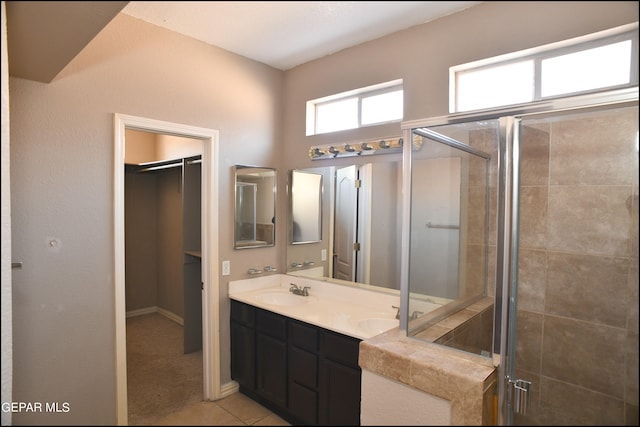 bathroom with tile patterned flooring, vanity, and an enclosed shower