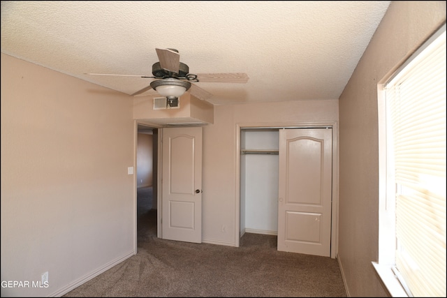 unfurnished bedroom featuring a textured ceiling, a closet, carpet, and ceiling fan