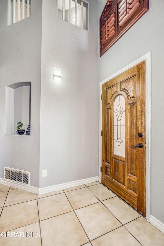 foyer with tile patterned floors and a high ceiling