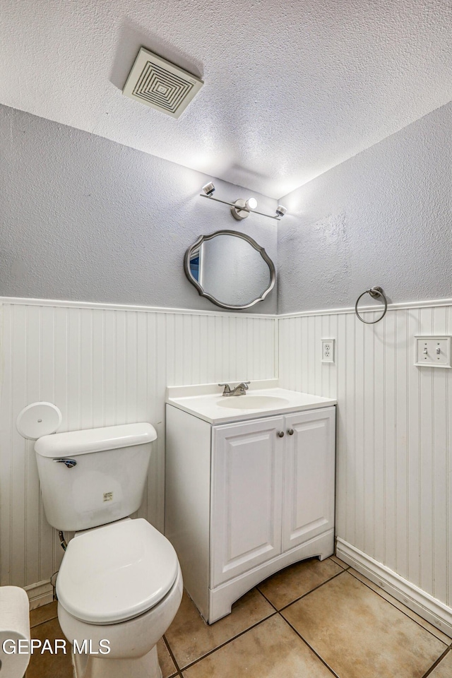 bathroom featuring tile patterned floors, vanity, and toilet