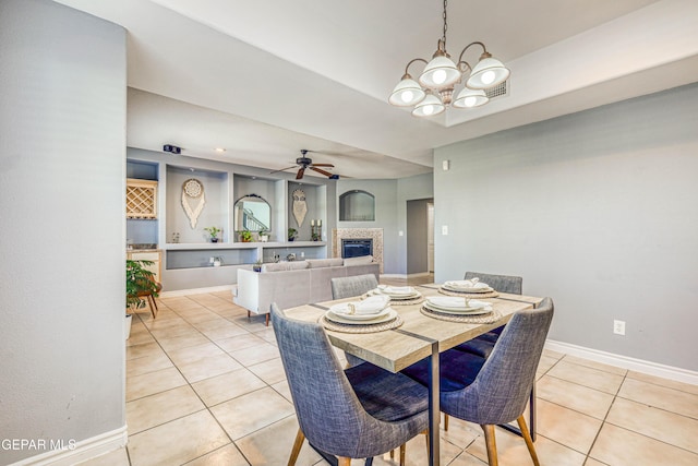 dining space featuring light tile patterned flooring and ceiling fan with notable chandelier