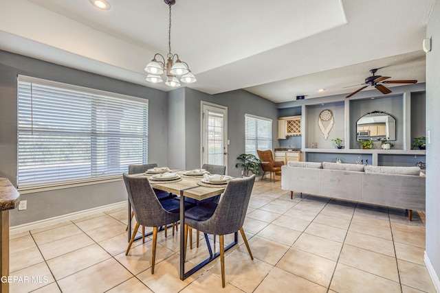 tiled dining room with ceiling fan with notable chandelier