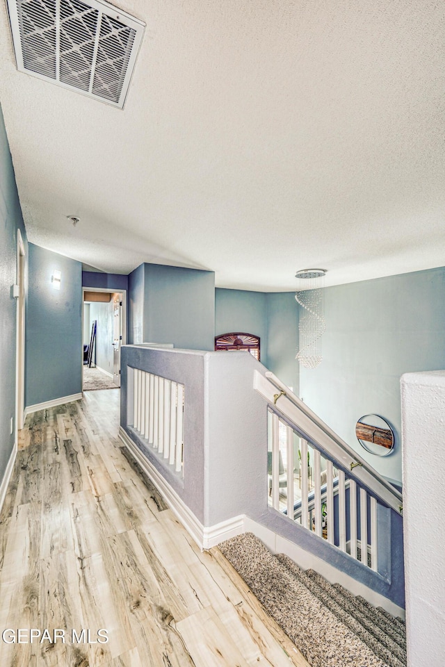 corridor featuring hardwood / wood-style flooring and a textured ceiling