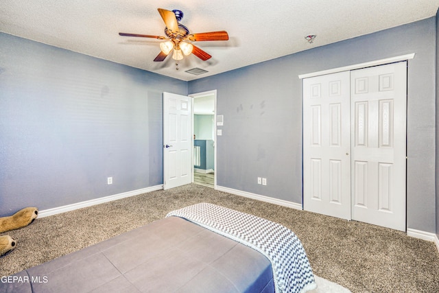 carpeted bedroom with a textured ceiling, a closet, and ceiling fan