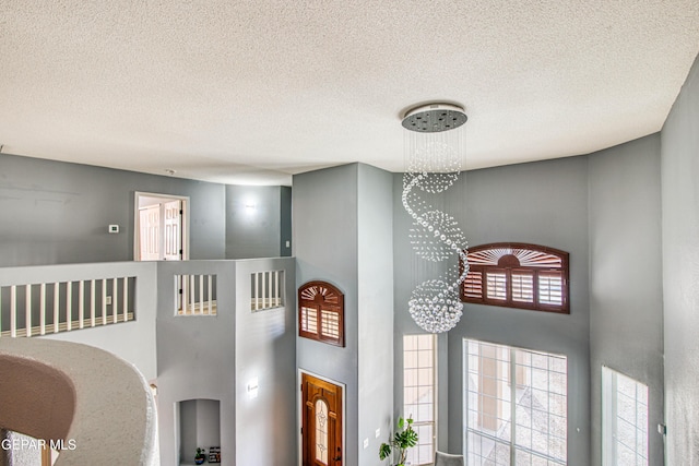 interior details with a textured ceiling and an inviting chandelier