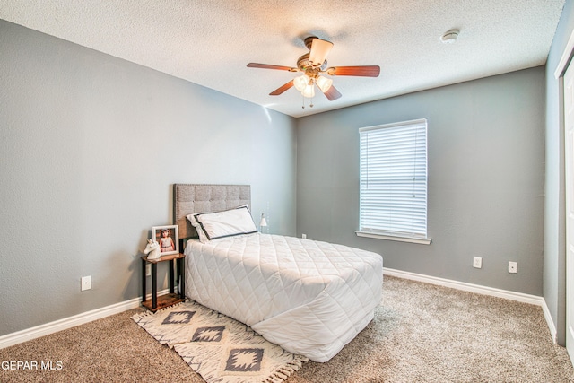 bedroom featuring ceiling fan, light carpet, and a textured ceiling