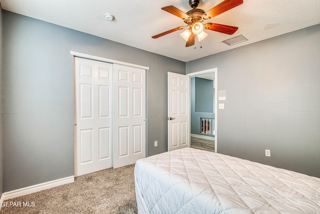 bedroom with ceiling fan, carpet floors, a textured ceiling, and a closet