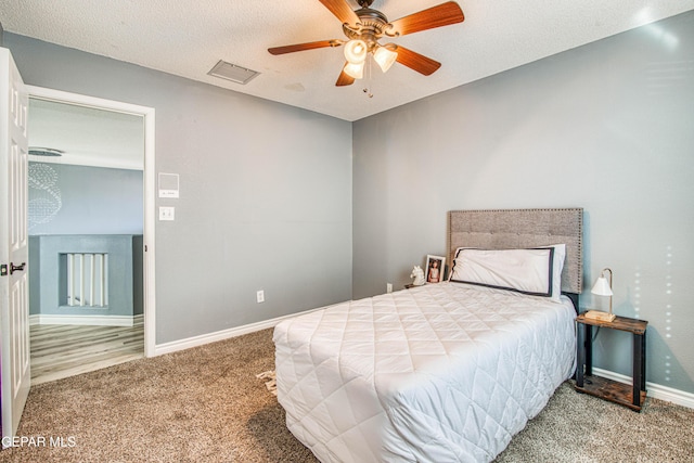 bedroom with carpet flooring, ceiling fan, and a textured ceiling