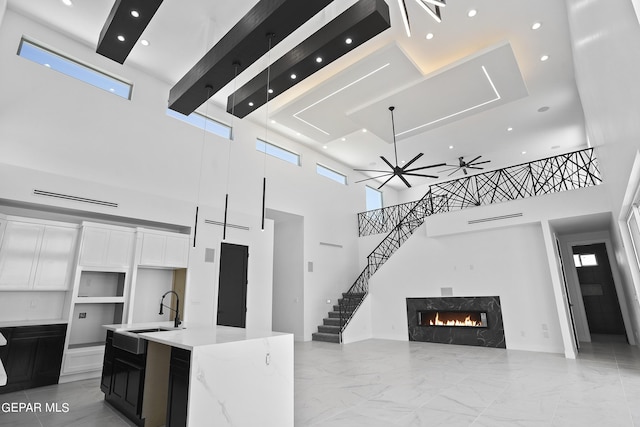 kitchen with a premium fireplace, white cabinetry, plenty of natural light, and sink