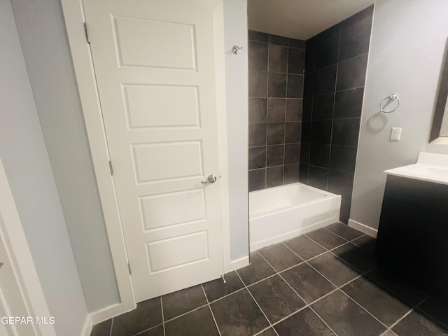 bathroom with tiled shower / bath, tile patterned flooring, and vanity