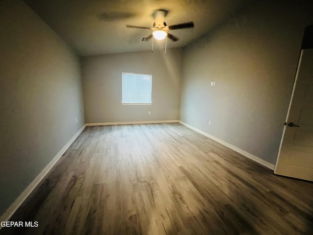 empty room featuring ceiling fan, vaulted ceiling, and wood-type flooring