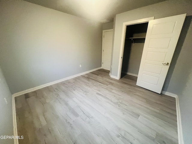 unfurnished bedroom featuring light hardwood / wood-style floors and a closet