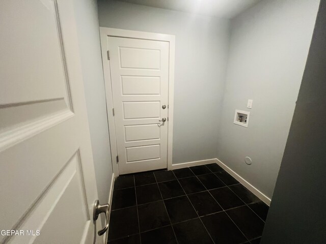 washroom with hookup for a washing machine and dark tile patterned flooring