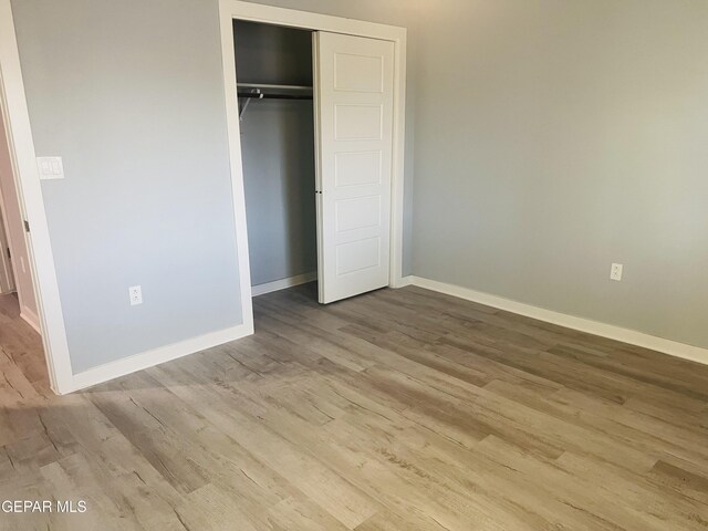 unfurnished bedroom with a closet and light hardwood / wood-style flooring