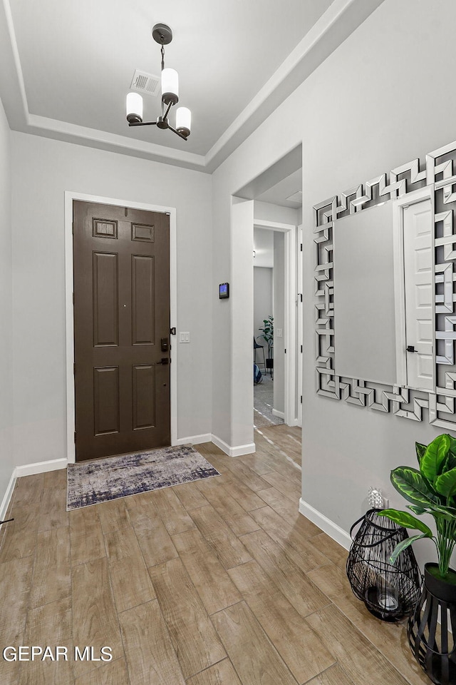 entrance foyer with light wood-type flooring and a notable chandelier