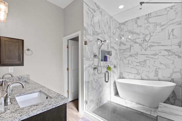 bathroom with vanity, tile walls, hardwood / wood-style floors, and plus walk in shower