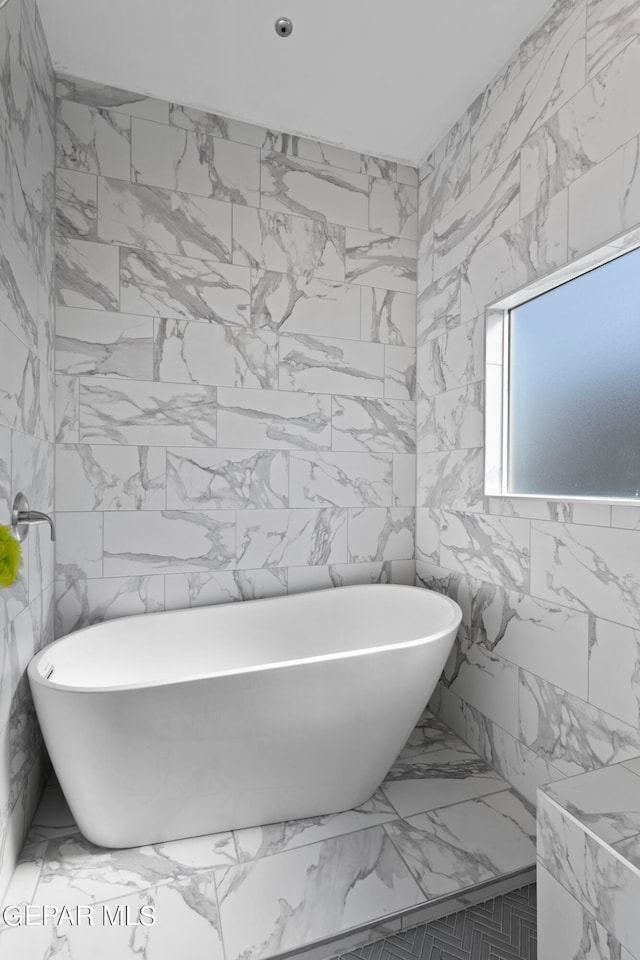 bathroom with a bathtub and tile walls