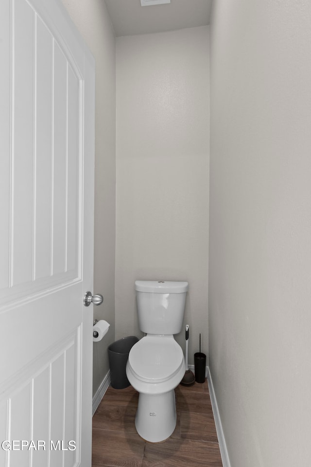 bathroom with toilet and wood-type flooring