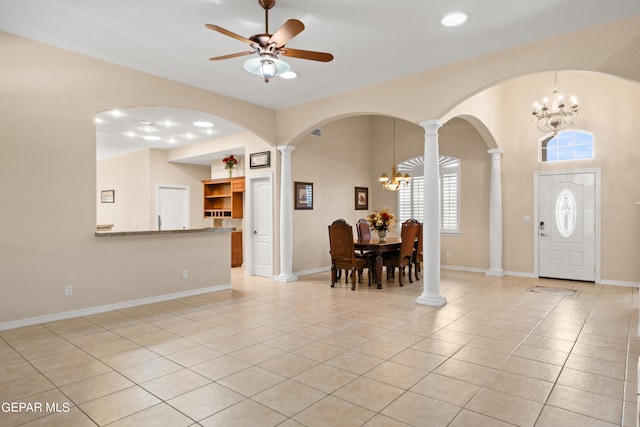 entryway with ceiling fan with notable chandelier, ornate columns, and light tile patterned floors