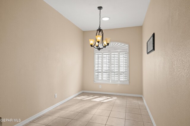 unfurnished room with light tile patterned floors and an inviting chandelier