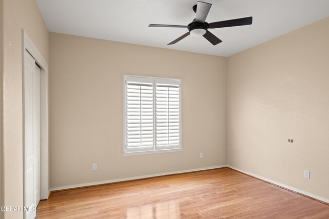 empty room with light hardwood / wood-style floors, a wealth of natural light, and ceiling fan