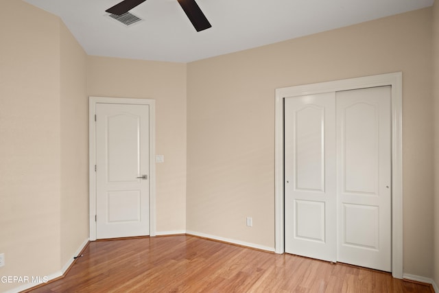 unfurnished bedroom featuring light hardwood / wood-style floors, a closet, and ceiling fan