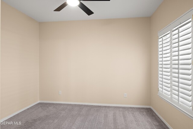 carpeted spare room featuring ceiling fan