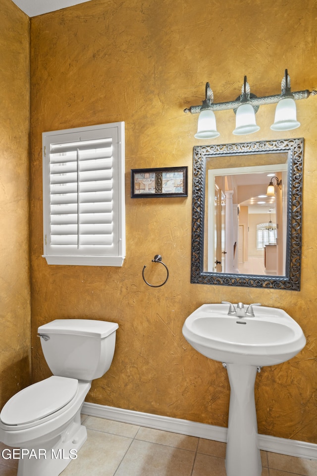 bathroom featuring tile patterned flooring, toilet, and a wealth of natural light