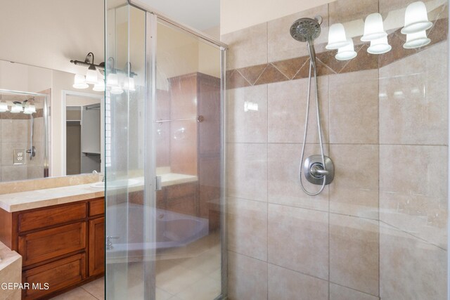 bathroom with tile patterned floors, vanity, and a shower with door