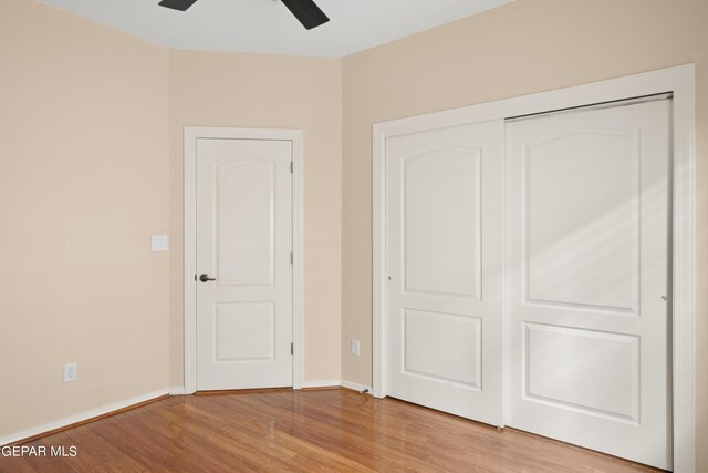 unfurnished bedroom with ceiling fan, light wood-type flooring, and a closet