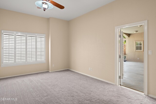 carpeted spare room featuring ceiling fan and a healthy amount of sunlight