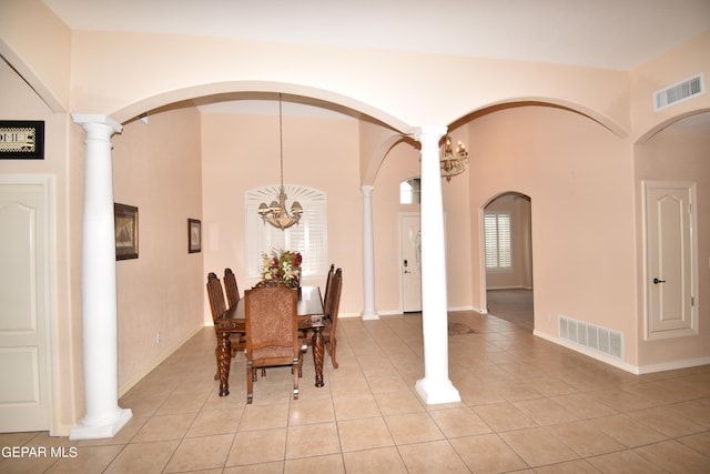 dining space with a notable chandelier, ornate columns, and light tile patterned floors