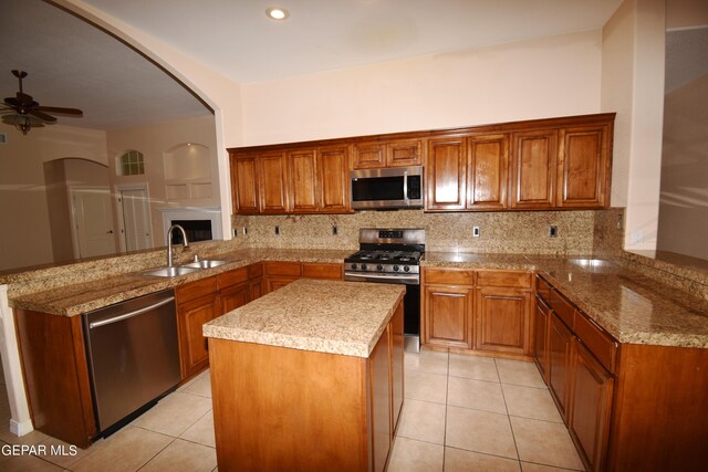 kitchen featuring kitchen peninsula, ceiling fan, stainless steel appliances, and light tile patterned floors