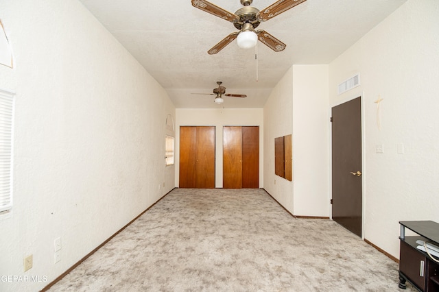 unfurnished bedroom with light colored carpet and ceiling fan