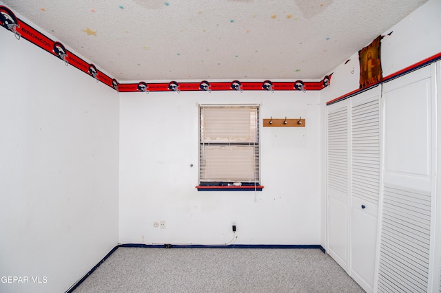 unfurnished room featuring a textured ceiling and light carpet