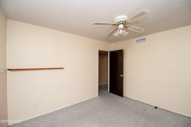 carpeted spare room with a textured ceiling and ceiling fan