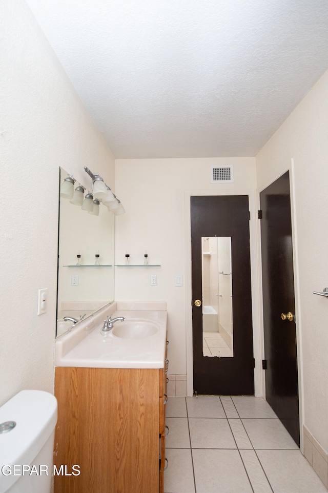 bathroom with tile patterned flooring, vanity, and toilet