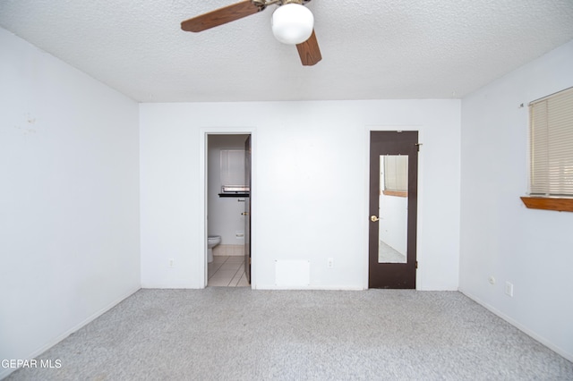 carpeted spare room with ceiling fan and a textured ceiling