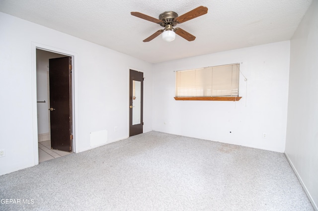 carpeted empty room featuring a textured ceiling and ceiling fan