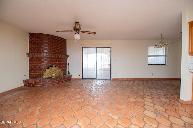 unfurnished living room featuring a fireplace, ceiling fan with notable chandelier, and a textured ceiling