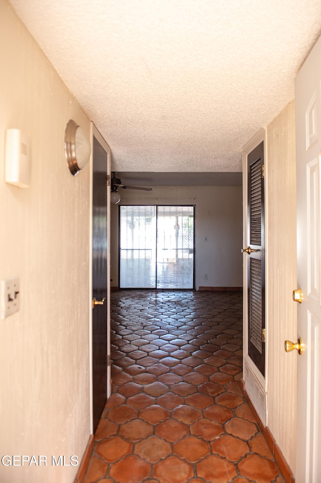 hall with a textured ceiling